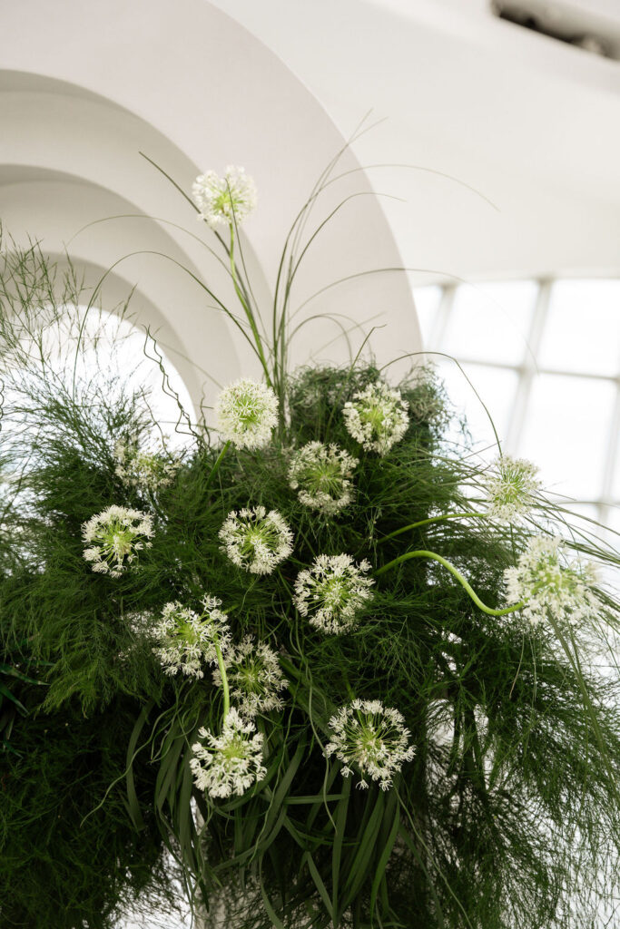 greenery on ceremony arch with pops of white florals