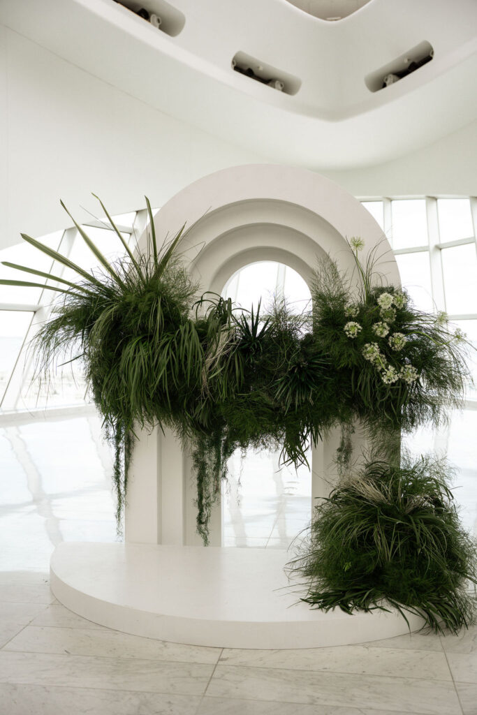 white ceremony arch with greenery