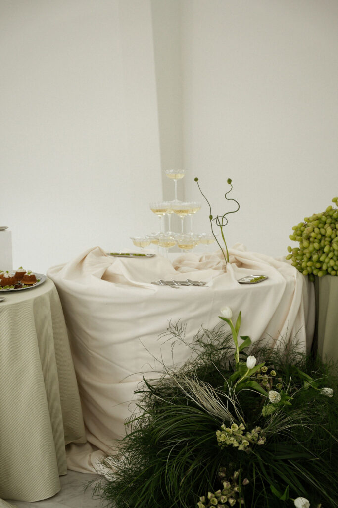 grazing table with champagne tower and sculptural green florals