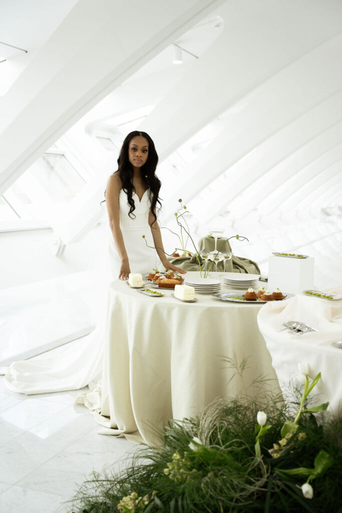 bride standing near cocktail hour grazing table